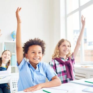 School-aged children raise their hands in a classroom setting. In 2000, measles was declared eliminated in the US — so why are some states, including nearby Kansas, having measles outbreaks now? The answer isn’t a mystery: fewer kids are getting vaccinated against measles.